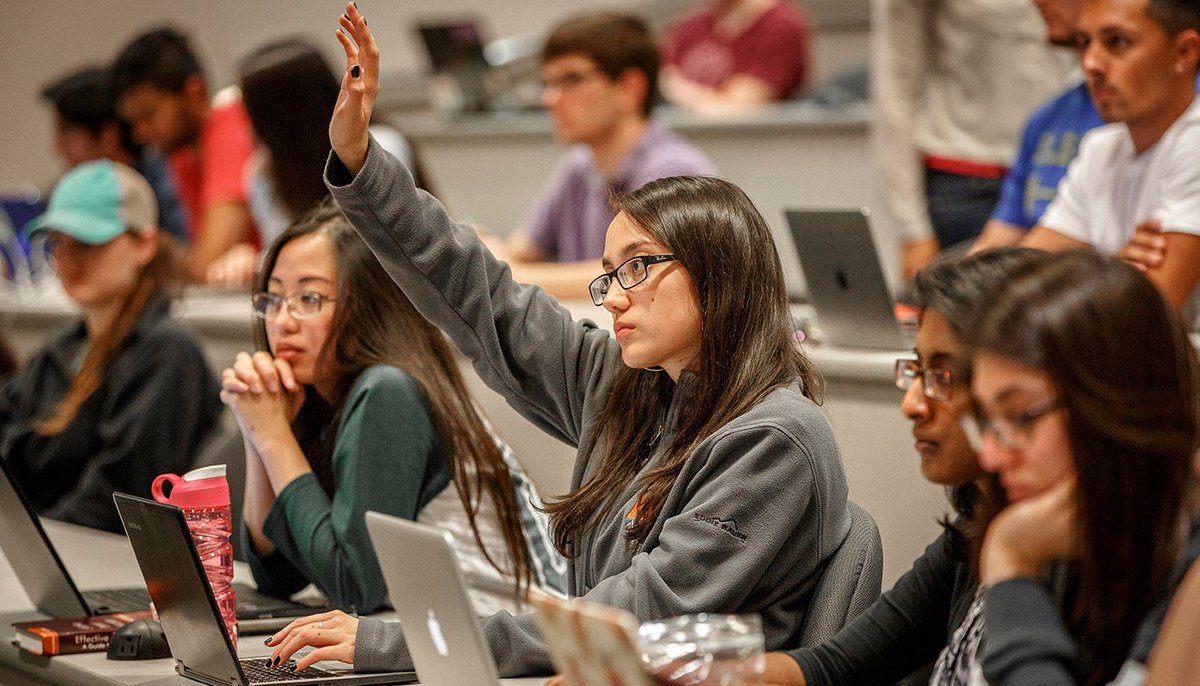 A picture of a student raising her hand during class.
